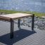 Thor table con gambe in metallo e piano in legno sistemato in riva al fiume.