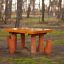 Table Nature with 4 stools realizzato in legno naturale posizionato all'aperto in un contesto boschivo