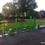 Attrezzatura da fitness all'aperto Ribbon Fitness II in vivace colore verde, installata in un contesto di parco.