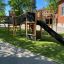 Struttura da gioco all'aperto per bambini Challenger Nature II in un parco giochi scolastico con uno scivolo e un ponte