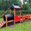 Casetta gioco a tema treno per bambini in un parco.