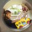 Bambino che gioca con il giocattolo Locomotive with cars train playhouse in uno scivolo a tubo.