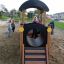 Bambini che giocano su Locomotive with cars train playhouse in un parco giochi.