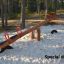 Nature Seesaw su un parco giochi sabbioso tra gli alberi.