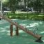 Nature Seesaw in un parco giochi con design in legno e maniglie in metallo.