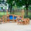 Attrezzatura da parco giochi in legno per Sand & Water Play III con panchine e tavoli.