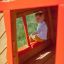 Bambino che gioca all'interno di Anna's Playhouse struttura in legno.