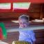 Bambino che gioca all'interno di Anna's Playhouse realizzata in legno.