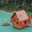 Anna's Playhouse, casetta da gioco in legno con dettagli rossi in un parco giochi colorato