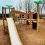 Jungle castle with slide in un parco giochi con alberi sullo sfondo.