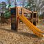 Parco giochi Jungle castle with slide realizzato in legno e decorato con motivi di animali.