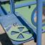 Attrezzature da gioco Pluto in primo piano con volante verde e struttura di arrampicata blu.