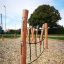 Struttura da arrampicata Katla con pali in legno e corde in un parco giochi.