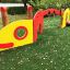 Baby Caterpillar wooden playhouse in rosso e giallo con una finestra circolare e una piccola piattafo