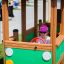 Bambino che gioca all'interno di un'attrezzatura da parco giochi in legno verde Bus.