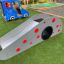 Scivolo da gioco per bambini Dottie I single slide con pois rossi su prato sintetico verde.
