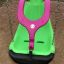 All Access Seat - altalena inclusiva per parco giochi con colori verde e rosa su terreno sabbioso