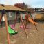 Double Seat swing in un parco giochi con superficie sabbiosa