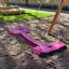 Double Seat swing in un parco giochi con terreno sabbioso.