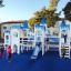 Bambini che giocano sulla struttura da parco giochi Winter Mansion con torri blu e bianche in stile castello a