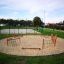 Area giochi all'aperto Trim Trail Nature III con strutture in legno e reti da arrampicata.
