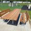 Table & Bench Steel Construction all'aperto in un'area ricreativa con erba e attrezzature da gioco
