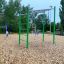 Attrezzatura da gioco all'aperto Monkey Bar con struttura verde e anelli sospesi in un contesto di parco.