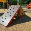 Casetta da gioco in legno a forma di tenda con parete da arrampicata nel parco giochi