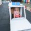 Bambino che gioca su un giocattolo Ambulance in un parco giochi all'aperto.