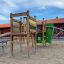 El Dorado wooden playhouse con scivolo e struttura da arrampicata in un parco giochi.