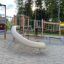 El Dorado wooden playhouse con scivolo e strutture da arrampicata in un parco giochi