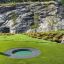 Round trampoline (80 cm) installato in un paesaggio verde con sfondo roccioso.