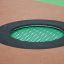 Round trampoline (100 cm) integrato nella superficie del parco giochi con imbottitura di sicurezza nera e verde