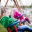 Due bambini che giocano su Double Baby Swing nel parco.