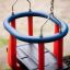 Double Swing per bambini con barre rosse e struttura blu.