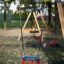 Double Swing in un parco giochi con alberi sullo sfondo