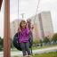Una ragazza sorride mentre si dondola su un'attrezzatura da gioco Double Swing.