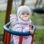 Un bambino in abiti caldi seduto su un Double Swing.