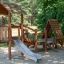 Galapagos wooden playhouse with slide in un contesto di parco