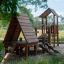 Galapagos wooden playhouse with slide in un contesto di parco.