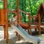 Galapagos wooden playhouse with slide in un ambiente di area giochi nel bosco