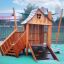 Tambora wooden playhouse with slide e parete da arrampicata su un'area giochi