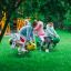 Bambini che giocano su attrezzature da parco giochi Grasshopper rocking su un prato