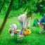 Bambini che giocano su altalene a molla Grasshopper rocking in un parco giochi verde.
