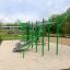 Struttura verde per fitness all'aperto, Grandis Training Set, in un parco con base in sabbia.