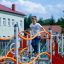 Bambino che scala il castello Ursa Maior con scivolo e rete da arrampicata, attrezzatura da parco giochi.