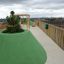 Superficie del parco giochi Wetpour 45 a forma di collina verde con alberi su un tetto.