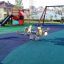 Parco giochi ricoperto di pavimentazione in gomma Wetpour 45, con scivoli e giochi a molla