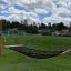 Triple Hammock in un parco giochi su uno sfondo di prato e case sullo sfondo