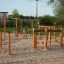 Attrezzatura da gioco in legno Trim trail con corde e travi di equilibrio su terreno sabbioso.
